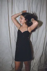 Vestido corto de color verde esmeralda, con escote en pico y breteles finos. Presenta aberturas en los laterales de la cintura y espalda descubierta.