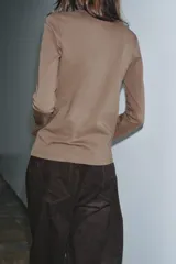 Camiseta de manga larga confeccionada en tejido de punto interlock elástico y flexible, con cuello redondo y bajo recto.