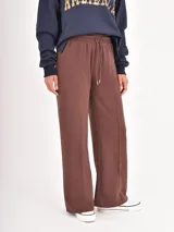 Pantalon de jogging de corte recto y tiro alto, confeccionado en tejido de algodón con costura vertical decorativa en el frente. Cuenta con cintura elástica con cordón de ajuste y bolsillos laterales.