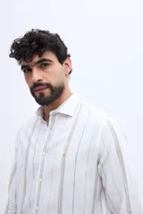 Camisa de manga larga con diseño de rayas verticales, confeccionada en mezcla de lino y algodón, con cuello camisero y cierre frontal de botones.