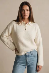 Sweater de punto con cuello polo y cierre frontal de tres botones. Presenta un diseño de corte oversize, mangas largas y textura acanalada.