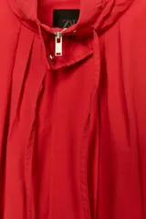 Cazadora bomber roja de la colección Zara Woman, con cuello subido ajustable con cordones, manga larga con puño elástico y stopper, bolsillos delanteros y cierre frontal con cremallera metálica y botones a presión ocultos.