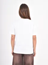 Remera de algodón blanca, de corte holgado y cuello redondo, con mangas cortas de diseño clásico.