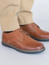 Zapato casual de cuero color marrón con cordones, costuras reforzadas y suela de EVA negra con detalle de vira clara.