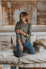 Remera de manga larga color verde oliva, con cuello redondo y tejido acanalado.