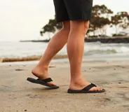 Ojotas Reef Phantom II negras con tiras texturizadas y logo de la marca en la tira superior.