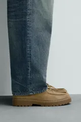 Zapato de cordones para hombre confeccionado en piel con acabado de serraje en color beige. Cuenta con detalle de bordón en el empeine, horma redonda y suela tipo track a tono.