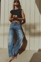 Jeans de tiro medio con diseño de cinco bolsillos, pernera recta y corte cropped. Presenta cierre frontal con cremallera y botón metálico.
