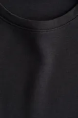 Buzo oversized de punto interlock pesado en color negro, con cuello redondo y mangas largas amplias.