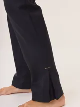 Pantalón de vestir azul marino, corte cigarette con pierna angosta y abertura en el bajo. Presenta costuras en contraste color beige y un botón marrón en la cintura.