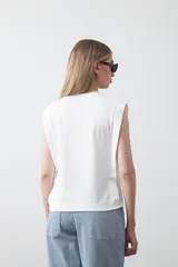 Remera sin mangas negra con hombros marcados y caída recta.