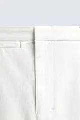 Pantalón barrel fit de hombre, confeccionado en denim de algodón color crudo. Presenta cintura con pliegues frontales, bolsillos laterales y cierre con cremallera y botón.