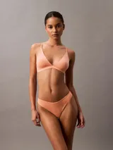 Bombacha tipo colaless Calvin Klein de la línea Ideal Cotton, confeccionada en mezcla de algodón elástico. Presenta un diseño de tiro medio con cintura fina y flexible, y refuerzo forrado en la entrepierna.