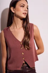 Chaleco de punto color ladrillo, con escote en V y cierre frontal con botones.