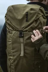 Mochila de senderismo y uso diario Thule AllTrail X 25L, color marrón nutria. Fabricada en lona de poliéster encerado reciclada, cuenta con compartimento principal con acceso lateral, funda interna para computadora portátil o hidratación, bolsillo frontal Shove-it, correas de compresión laterales, cinturón de cadera ajustable y panel posterior respirable.