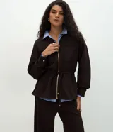 Campera tipo parka color verde oscuro, confeccionada en modal con cierre frontal metálico, cuello camisero, bolsillos frontales y cordón ajustable en la cintura.