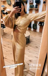 Pantalón de tiro alto confeccionado en tejido de lamé dorado con acabado brillante y corte ligeramente evasé.