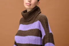Sweater de punto grueso con cuello alto tipo polera, diseño a rayas horizontales en colores marrón y lila, de calce relajado y mangas amplias.