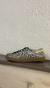 Championes de cuero con estampado animal print en blanco y negro, cordones negros y suela de goma color caramelo.