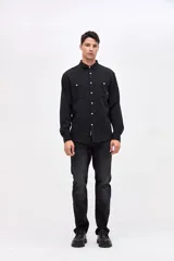 Camisa de corte regular fit confeccionada en algodón, con cuello solapa clásico, cierre frontal con botones y dos bolsillos frontales en el pecho.