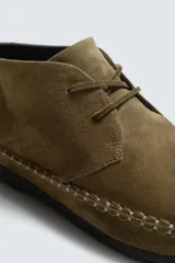 Zapato tipo derby de cordones, confeccionado en piel con acabado de serraje. Presenta costuras decorativas en el contorno de la suela, horma redonda y suela de goma Vibram.