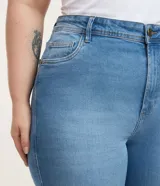 Pantalón de jean femenino azul claro, modelo flare, con silueta ajustada en caderas y muslos, y acampanado desde la rodilla. Cuenta con cintura media, cierre de botón y cremallera, bolsillos delanteros curvos y bolsillos traseros tradicionales. Confeccionado en algodón más sostenible con elastano.