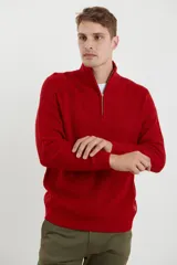 Sweater verde de punto inglés con cuello alto y cierre metálico frontal. Tiene mangas largas y terminaciones en punto canalé.