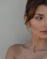 Aros de diseño minimalista en forma de corazón irregular, con acabado metálico pulido y cierre de perno con mariposa.