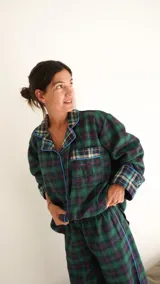 Conjunto de pijama a cuadros con ribetes en color lila, compuesto por camisa de manga larga con botones y pantalón largo.