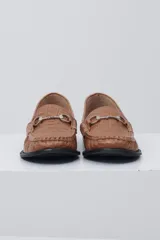 Mocasín negro de cuero con textura tipo cocodrilo, detalle de estribo metálico plateado en el empeine y costuras reforzadas en la puntera.