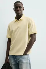 Polo de hombre color verde oliva, de corte regular fit, con cuello solapa y cierre frontal de botonadura. Presenta manga corta y acabados en rib.