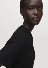 Vestido corto de tejido de punto fino en color negro, con cuello perkins, mangas cortas y diseño evasé.