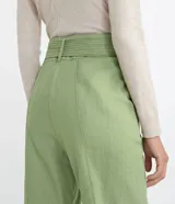 Pantalón carrot de Marfinno en color verde, confeccionado en mezcla de viscosa y lino. Presenta tiro medio, cierre frontal con cremallera, bolsillos, costuras frontales marcadas y detalle de cinturón incorporado con hebilla circular.