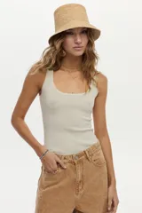 Musculosa de tejido rib color crudo, con lurex incorporado y escote redondo, de calce ajustado al cuerpo.