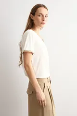 Remera negra de manga corta con escote en V y sutil detalle de lurex brillante en el cuello y las mangas.