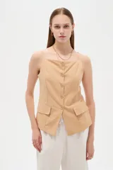 Top de viscosa color blanco con tirantes finos, cuello a la base y cierre frontal con botones. Presenta bolsillos appliqués con solapa en la parte inferior y diseño al cuerpo.