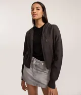 Campera corta de punto color gris oscuro, con capucha ajustable mediante cordones, cierre frontal de cremallera y mangas largas con puños acanalados.