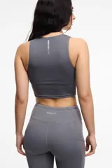 Top deportivo color gris oscuro, con escote a la base, copas removibles y largo a la cintura.