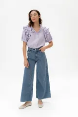 Camisa celeste de lino con cuello mao y mangas cortas abullonadas con volados. Cierre frontal con botones.