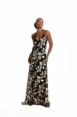 Vestido largo negro de tul con diseño bordado floral en tonos dorados, con escote halter y silueta fluida.