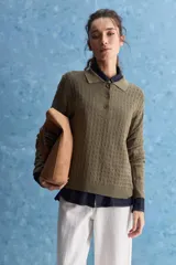 Sweater de punto color verde militar, con cuello polo y cierre frontal de botones, de manga larga con puños elastizados y diseño texturizado con relieve geométrico.