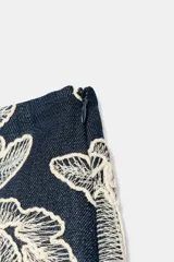 Falda pantalón corta de color azul marino con diseño bordado de flores en hilo crudo, forro interior y cierre lateral con cremallera oculta.