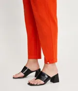 Pantalón zanahoria color naranja, marca Cortelle, con pliegues, bolsillos laterales y traseros, detalle de botón en los bajos y cierre en la cintura por botón.