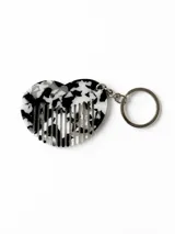 Llavero con dije en forma de corazón con diseño efecto carey en blanco y negro, que incluye función de peine integrado. Cuenta con argolla y cadena metálica plateada.