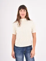 Polera de manga corta con cuello alto, confeccionada en tejido con estampado animal print tipo cebra en tonos claros.