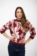 Buzo de tejido de punto con diseño de rombos y flores estampadas en tonos bordó, rosa y crema. Presenta cuello redondo, mangas largas y puños acanalados.