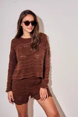 Sweater oversize de tejido de punto color blanco con diseño calado de ondas y cuello redondo, de manga larga.