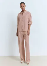 Camisa de corte recto y diseño a rayas verticales en tonos terracota y blanco, con cuello camisero, cierre frontal de botones y mangas largas con puños abotonados.