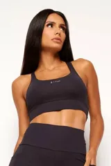 Top deportivo de alto rendimiento con diseño de espalda nadador, confeccionado en tejido técnico con protección UV50+. Presenta un bolsillo interno en el forro frontal y detalles reflectivos.