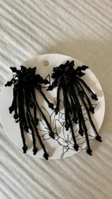 Aros colgantes negros con cuentas y flecos.